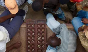 Men playing a wooden board game. 