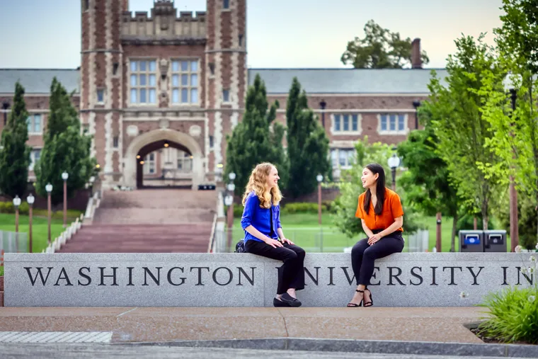 Two women seated in front of Brookings Hall