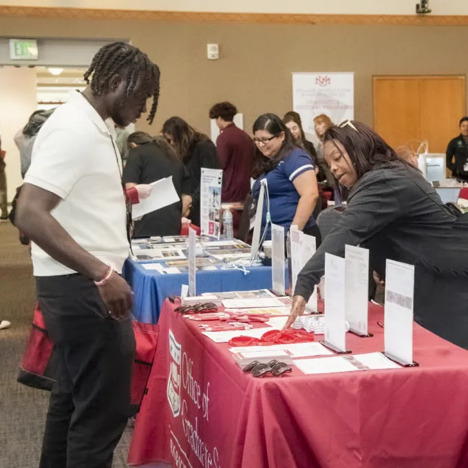 "Recruiter and student speaking at a conference"