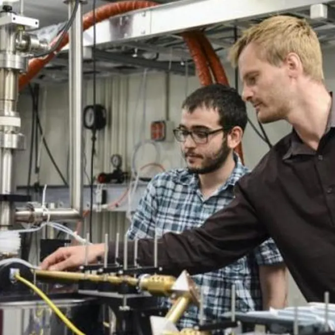 Two men working on a machine. 