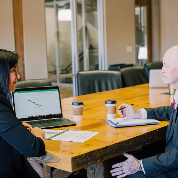 man and woman sit across a table form one another